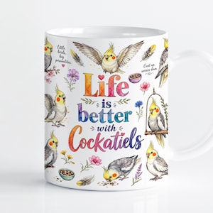 Może przedstawiać: Biały ceramiczny kubek z kolorowymi akwarelowymi ilustracjami nimf w różnych pozach, rozrzuconymi piórami, małymi kwiatami i miseczkami z ziarnem. Tekst głosi, Life is better with Cockatiels, Little birds, big personalities, oraz Crest up, worries down.