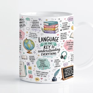 Puede incluir: Una taza de cerámica blanca con una ilustración colorida de libros, un globo terráqueo, auriculares y una pluma. El texto dice: Language is the key to understanding everything, junto con varias frases sobre el lenguaje, la comunicación y el aprendizaje.
