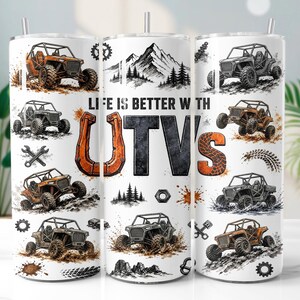 Może przedstawiać: Biały cylindryczny kubek z powtarzającym się wzorem pomarańczowych i szarych pojazdów terenowych UTV, sylwetek gór oraz części mechanicznych. Napis LIFE IS BETTER WITH UTV'S jest wydrukowany dużymi pomarańczowo-czarnymi literami blokowymi.