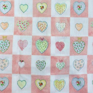 Puede incluir: Tela a cuadros rosa y blanca con un patrón repetido de corazones de patchwork coloridos. Los corazones son de varios tonos de rosa, verde, amarillo y azul.