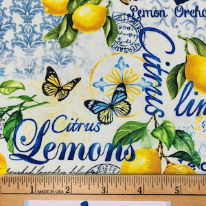 May include: Fabric with a lemon and butterfly design. The fabric features yellow lemons, green leaves, and blue text that reads "Citrus Lemons" and "Lemon Orchard". The background has a white and blue damask pattern.