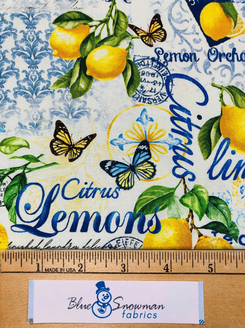 May include: Fabric with a lemon and butterfly design. The fabric features yellow lemons, green leaves, and blue text that reads "Citrus Lemons" and "Lemon Orchard". The background has a white and blue damask pattern.