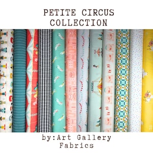 以下が含まれることがあります： Art Gallery Fabricsの「Petite Circus Collection」の生地ロール。サーカスのテントや幾何学模様など、赤、ティール、黒、黄色の様々なパターンがロールに表示されています。