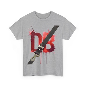 Op de afbeelding: Een grijs T-shirt met een rood en zwart grafisch ontwerp. De grafiek toont de letters "DB" met een zwarte band eroverheen. De letters zijn zo ontworpen dat ze eruit zien als verfspatten.