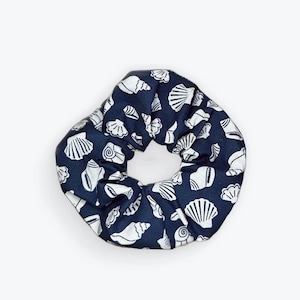May include: A navy blue scrunchie with a white seashell pattern.