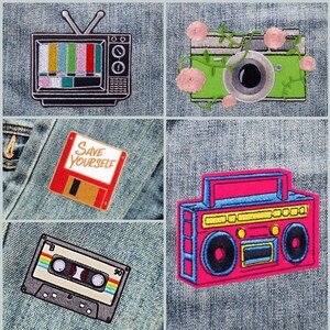 May include: Five embroidered patches on a denim background. The patches are a vintage television, a camera with vines, a floppy disk with the text "Save Yourself", a cassette tape, and a boombox.