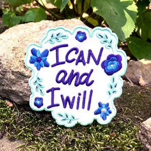 May include: White embroidered patch with a purple floral border and the text "I CAN and I WILL" in purple lettering.