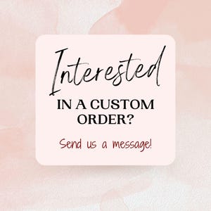 May include: A square sign with rounded corners featuring a pale pink background. The text reads Interested IN A CUSTOM ORDER? in black, followed by the red text Send us a message! The design is set against a soft, light pink watercolor wash.