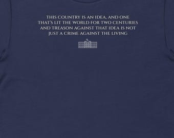 May include: Navy blue t-shirt with white text: "THIS COUNTRY IS AN IDEA, AND ONE THAT'S LIT THE WORLD FOR TWO CENTURIES AND TREASON AGAINST THAT IDEA IS NOT JUST A CRIME AGAINST THE LIVING." The text is above a graphic of the White House.