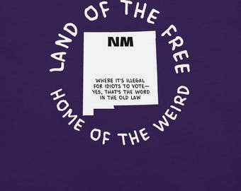 May include: A purple graphic tee with a white outline of New Mexico, the letters "NM", and the text "Land of the Free, Home of the Weird". The shirt also includes the text "Where it's illegal for idiots to vote - Yes, that's the word in the old law."