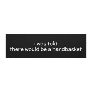 May include: A black rectangular sign with white text that reads "i was told there would be a handbasket."