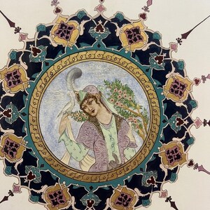 May include: A circular miniature painting featuring a figure in a lavender patterned garment with a white bird perched on their hand. The central scene is framed by an intricate border of dark blue, gold, and teal floral and geometric motifs.
