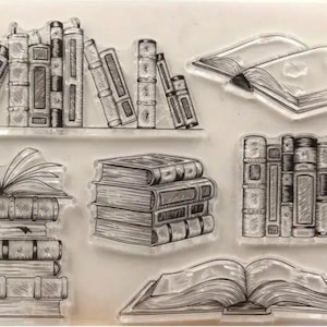 May include: Six clear stamps featuring different designs of books. The stamps are perfect for scrapbooking, card making, and other paper crafts.