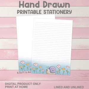 Puede incluir: Dos hojas de papelería imprimible, una rayada y otra en blanco. La parte inferior de las hojas presenta un diseño de acuarela con flores y un caracol. El texto "Hand Drawn Printable Stationery" está en la parte superior. El texto "8.5x11 & A4" está en la parte inferior.