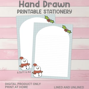 May include: Two sheets of printable stationery with a light blue grid pattern and a snowman graphic. The top of each sheet has a holly and berry design. One sheet is lined, the other is unlined. Text on the image reads "Hand Drawn Printable Stationery".