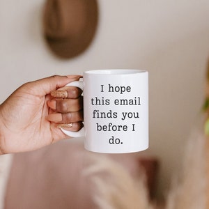 May include: White ceramic mug with black text that reads "I hope this email finds you before I do."