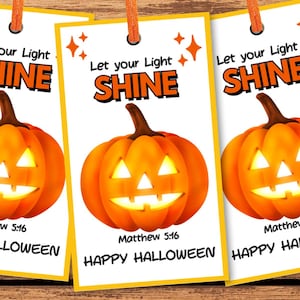 May include: Three Halloween-themed bookmarks with orange pumpkins and the text "Let your Light SHINE" and "Happy Halloween". The bookmarks are on a wooden surface with Halloween-themed candies and decorations.