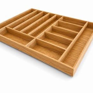 Può includere: Un vassoio portaposate rettangolare in legno marrone chiaro con scomparti multipli di varie dimensioni. L'organizzatore è realizzato in legno naturale con una venatura visibile, progettato con diversi divisori verticali e orizzontali.