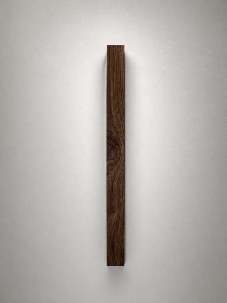 May include: A vertical, rectangular wooden object with a rich, dark brown color and visible wood grain. The object appears to be a decorative element or a piece of furniture, possibly a door pull or a wall accent. The wood has a natural, organic appearance.