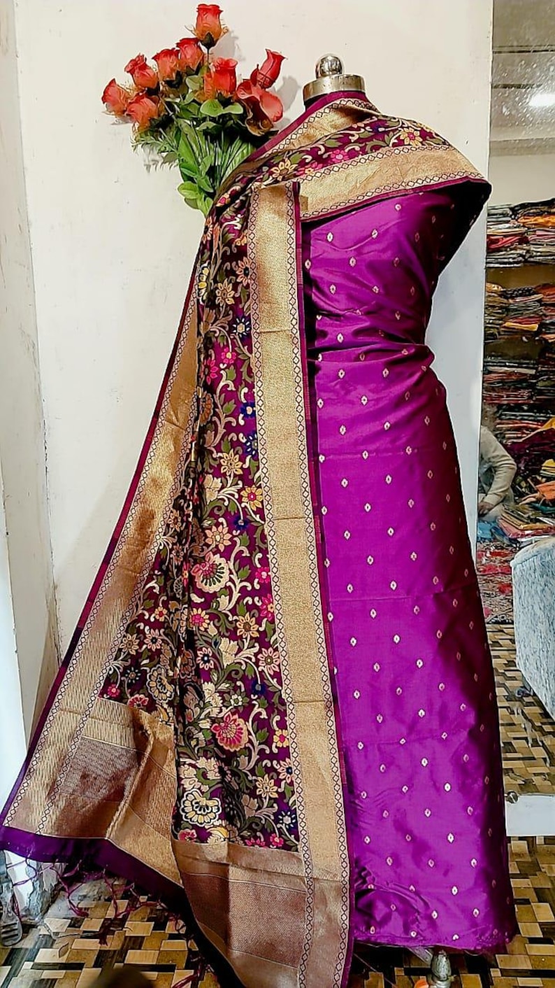 May include: A purple and gold silk dupatta with a floral pattern and a purple silk dress with a white polka dot pattern.