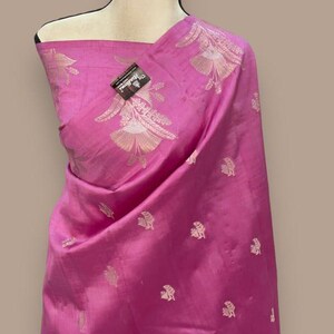 Puede incluir: Un sari de seda rosa con un patr&oacute;n floral plateado. El sari est&aacute; drapeado en un maniqu&iacute;.