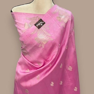 Puede incluir: Un dupatta de seda rosa con un patr&oacute;n floral plateado. El dupatta est&aacute; drapeado sobre un maniqu&iacute;.