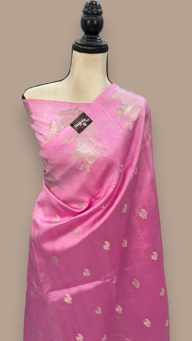 Puede incluir: Un dupatta de seda rosa con un patr&oacute;n floral plateado. El dupatta est&aacute; drapeado sobre un maniqu&iacute;.