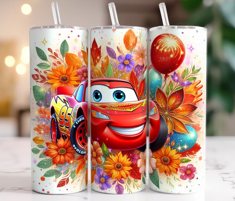 May include: A white tumbler with a red, yellow and green floral design. The tumbler features a cartoon image of a red racing car with a smiling face. The car is surrounded by flowers and leaves.