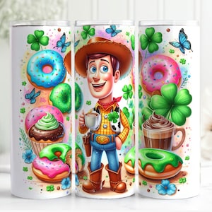 May include: A white tumbler with a green, pink, and brown design. The design features a cartoon character of Woody from Toy Story wearing a green vest and holding a cup of coffee. The design also includes donuts, shamrocks, and cupcakes.