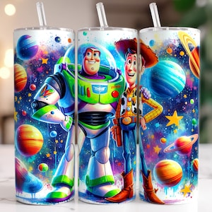 May include: A set of three white tumblers with a colourful space-themed design featuring Woody and Buzz Lightyear from Toy Story. The tumblers have a galaxy background with planets, stars, and splattered paint.
