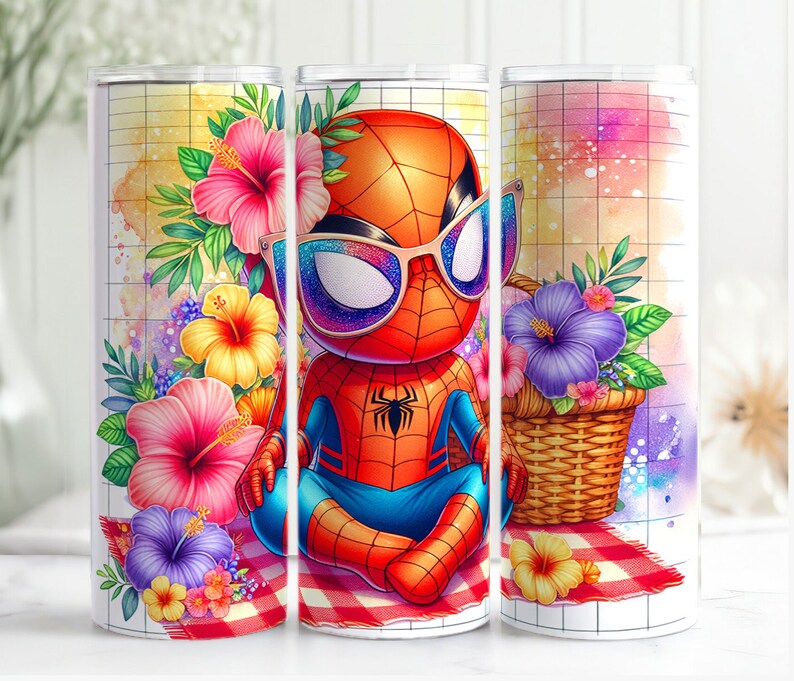 May include: A white tumbler with a red and blue cartoon superhero wearing sunglasses and sitting on a picnic blanket with flowers. The tumbler has a white background with a grid pattern.