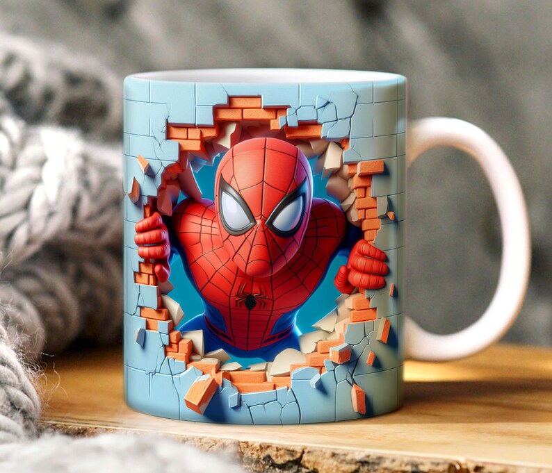 May include: A blue ceramic mug with a 3D image of Spiderman breaking through a brick wall. The mug has a white handle.