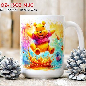 May include: White ceramic mug with a colorful watercolor design featuring Winnie the Pooh jumping in a pool of honey. The mug has a handle and says "Honey" on a jar of honey in the design.