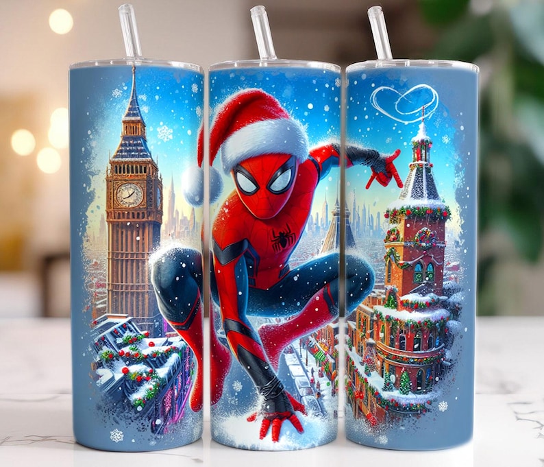 May include: Three blue insulated tumblers with white straws. Each tumbler features a winter scene with a superhero wearing a Santa hat. The background includes iconic buildings and falling snow, creating a festive holiday theme.
