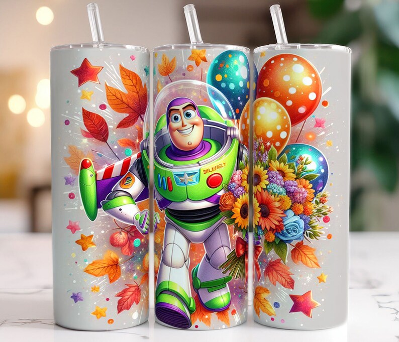 May include: A white tumbler with a colourful design featuring a cartoon image of Buzz Lightyear from the Toy Story franchise. The design also includes autumn leaves, flowers, and balloons.