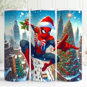 May include: A stainless steel tumbler with a festive design of Spider-Man in a Santa hat, set against a snowy cityscape with a Christmas tree. The artwork is vibrant with red, blue, and white colours, perfect for holiday gifting.