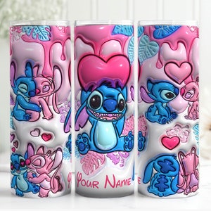 K&ouml;nnte beinhalten: Drei rosafarbene und blaue Edelstahlbecher mit einem Cartoon-Bild von Stitch und Angel aus dem Disney-Film Lilo & Stitch. Die Becher haben ein rosafarbenes und wei&szlig;es, tropfendes Maldesign mit Herzen und Bl&auml;ttern. Der Text "Your Name" ist auf den mittleren Becher gedruckt.