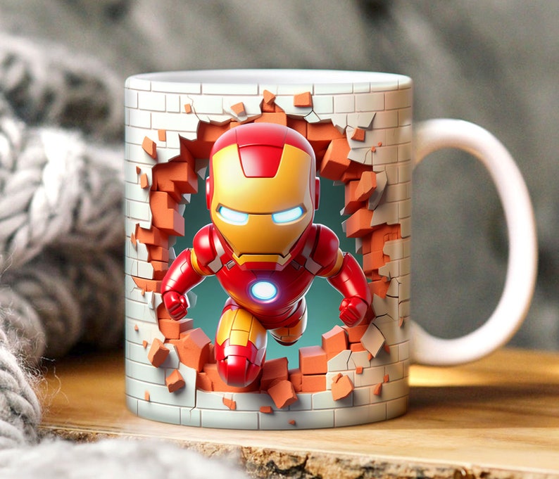 May include: A white ceramic mug with a 3D image of Iron Man breaking through a brick wall. The mug has a handle on the right side.