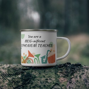Pode incluir: Caneca de esmalte branco com um design colorido de instrumentos musicais e o texto "You are a MUG-nificent EUPHONIUM TEACHER".