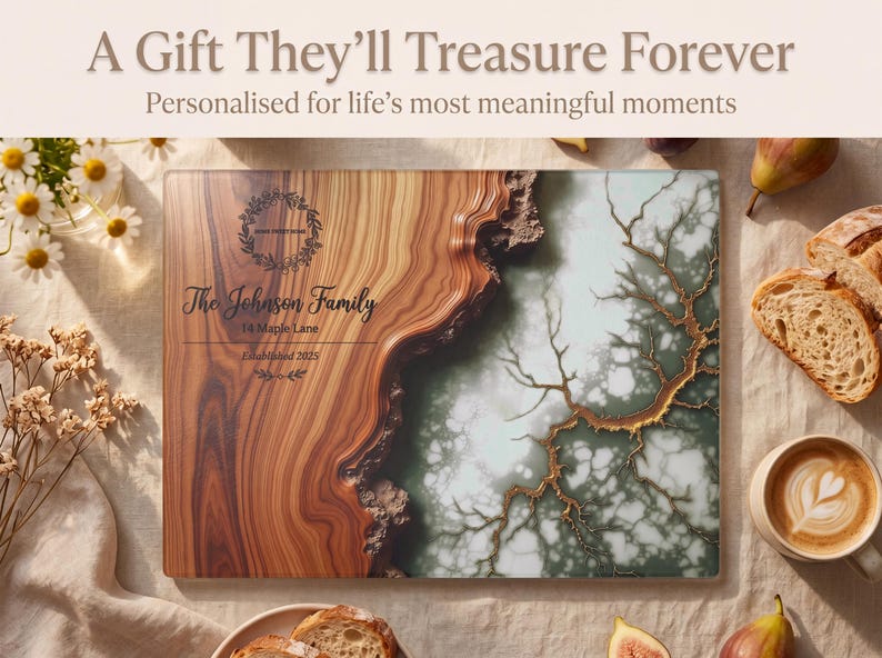 May include: A personalized wooden cutting board with a unique design. The board features a wood grain pattern on one side and a decorative design on the other. Text on the board reads "The Johnson Family" and "14 Maple Lane". The image also includes flowers, bread, and coffee.