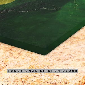 Puede incluir: Primer plano de una tabla de cortar rectangular verde oscuro con un dise&ntilde;o similar al m&aacute;rmol. La tabla de cortar est&aacute; sobre una encimera marr&oacute;n claro. El texto "FUNCTIONAL KITCHEN DECOR" est&aacute; en la parte inferior.
