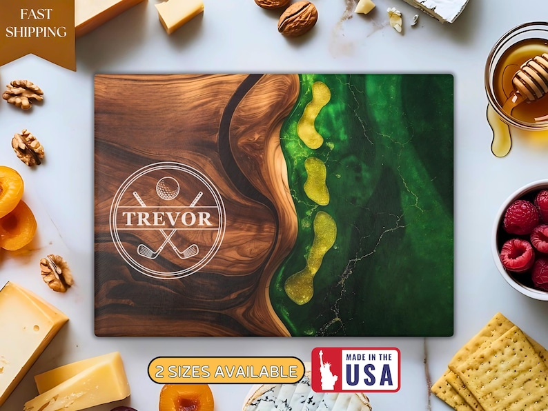 Puede incluir: Tabla de cortar rectangular de madera con dise&ntilde;o de campo de golf. La tabla presenta un patr&oacute;n de vetas de madera marr&oacute;n a la izquierda y un dise&ntilde;o de resina epoxi verde y amarilla a la derecha. La tabla tiene el nombre "TREVOR" en un c&iacute;rculo blanco.