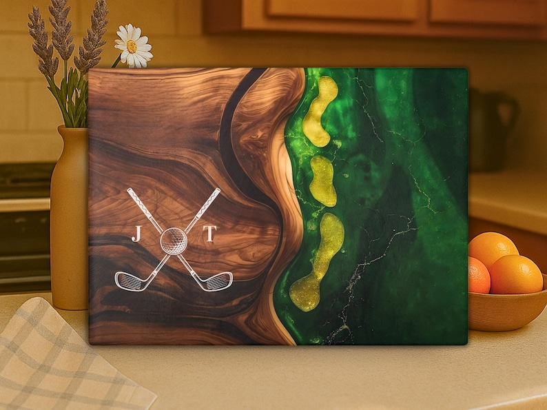 Puede incluir: Una obra de arte de madera con tem&aacute;tica de golf con un dise&ntilde;o &uacute;nico. La obra presenta una combinaci&oacute;n de madera oscura y resina epoxi verde, con un dise&ntilde;o de campo de golf. El dise&ntilde;o incluye palos de golf cruzados, una pelota de golf y las letras "J" y "T".