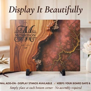 May include: A wooden cutting board with a unique design, featuring a blend of brown and red hues with a decorative pattern. The board is displayed on black stands, with the text "Display It Beautifully" at the top.