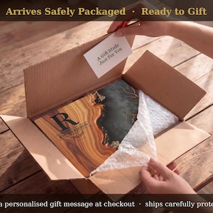 May include: A wooden gift inside a cardboard box, with the text "A Gift Made Just For You" on a tag. The gift has a wood grain design with the name "RICHARDSON" on it. The box is on a wooden surface.