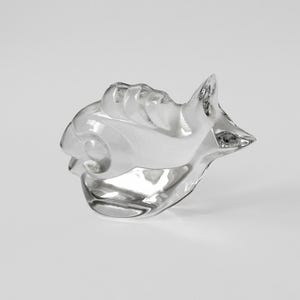 Pode incluir: Uma escultura de raposa estilizada em vidro transparente. A escultura é abstrata e tem um acabamento liso e polido.