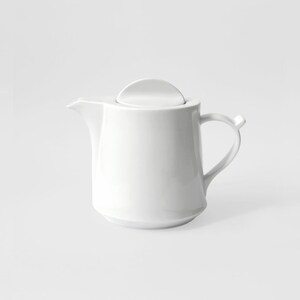 Puede incluir: Una tetera de cerámica blanca con tapa y asa. La tetera está diseñada con un estilo simple y moderno.