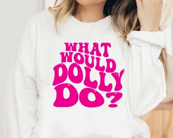May include: White sweatshirt with a pink graphic that says "What Would Dolly Do?" in a retro font.