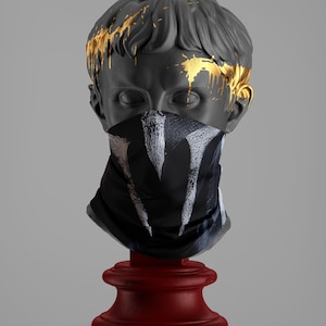 以下が含まれることがあります： 金色の塗料が飛び散った灰色の石膏の胸像が、白黒の模様のフェイスマスクを着用しています。胸像は赤い台座の上に置かれています。