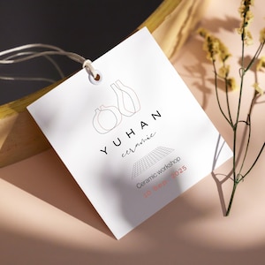 May include: White tag with a black and pink line drawing of two vases. The text "YUHAN ceramic" is below the vases. The text "Ceramic workshop 10 Sep. 2025" is below the logo.